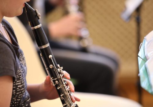 Close-up of a baby girl playing a black clarinet mouthpiece in h